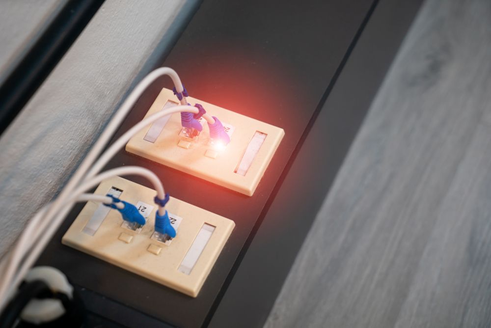 Close-up view of Ethernet ports with cables and illuminated LED indicator. Modern data connection setup.