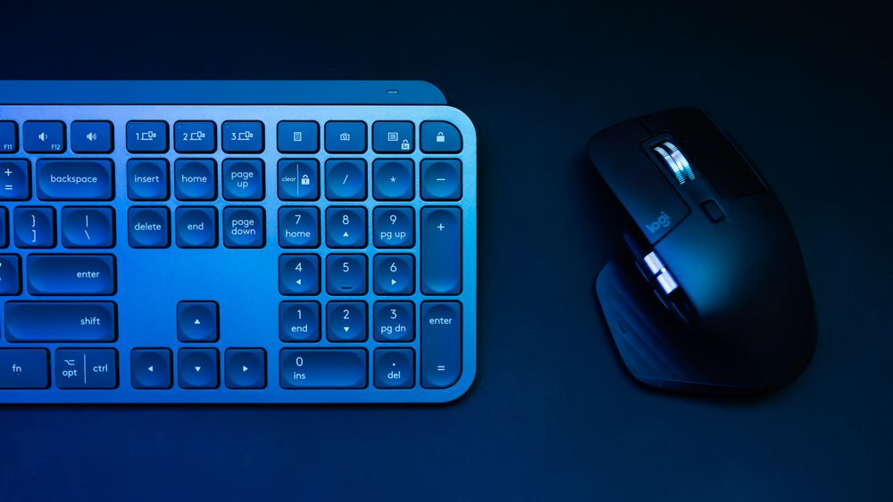 Sleek blue-lit wireless keyboard and mouse, ideal for tech themes.